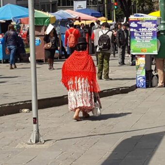 Central square with traditionally dressed Aymara woman or cholitas bolivia