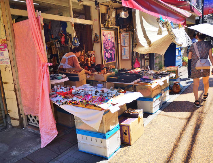Outdoor shop with merchandise displayed on tables along the street in Yanaka Ginza Tokyo
