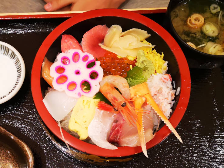 Traditional Japanese seafood meal in Kanazawa featuring fresh raw fish sashimi, served as part of local cuisine