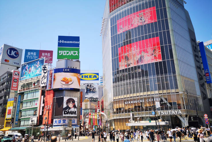 Buildings with large advertising screens and neon billboards at Shibuya Crossing in Tokyo
