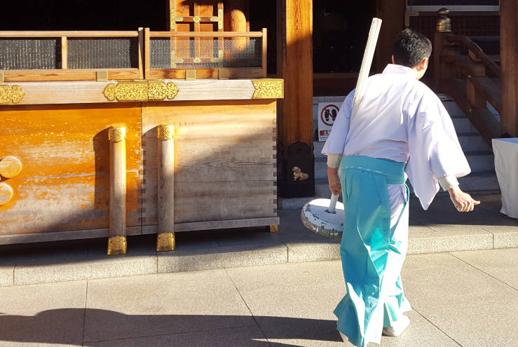 Monk at Yushima Tenjin Shrine during the morning of a plum blossom festival in Tokyo