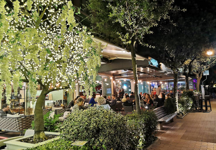 People dining outside at a restaurant in Montecatini Terme in the evening
