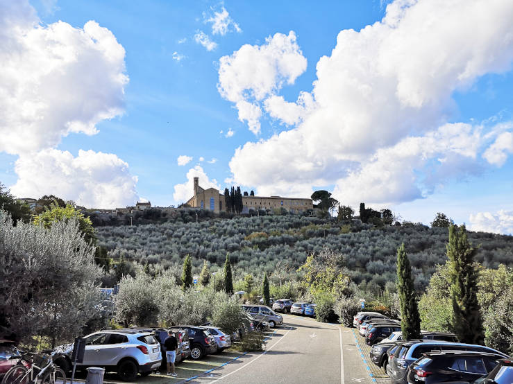 Medieval tower of San Gimignano above olive groves and the surrounding Tuscan landscape