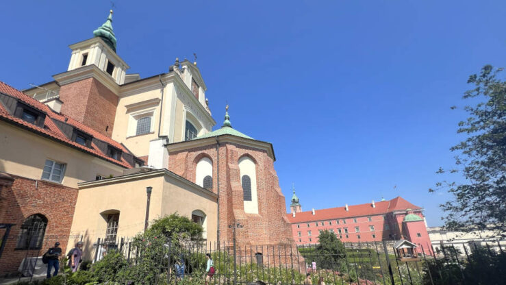 View of St Anne’s Church and Bell Tower, with the Royal Castle in the background, from the garden behind the church in Warsaw